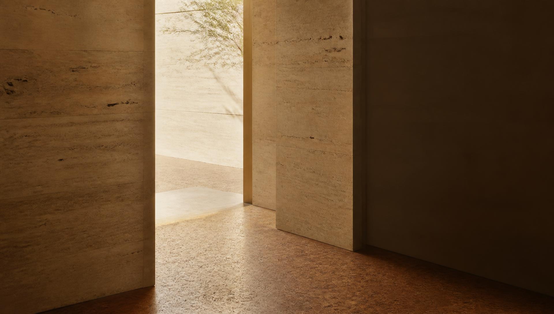 A narrow doorway in a warm travertine wall opening onto soft daylight above a cork floor